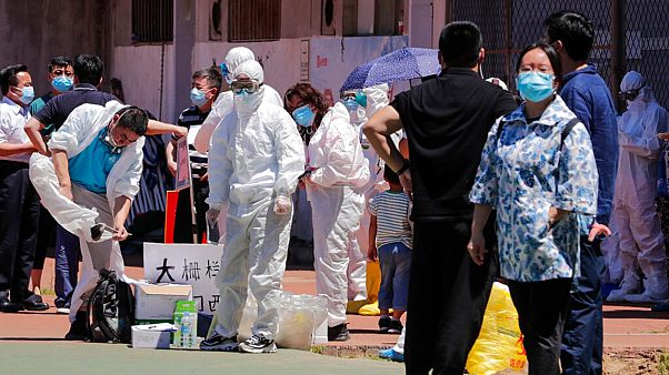 Workers put on protective suits as they wait for people living near the Xinfadi wholesale market arrive to get a nucleic acid test at a stadium in Beijing, June 14, 2020 Workers put on protective suits as they wait for people living near the Xinfadi wholesale market arrive to get a nucleic acid test at a stadium in Beijing, June 14, 2020