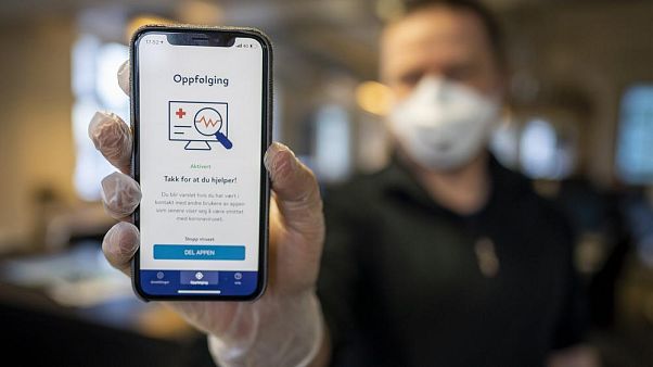 A man holds a mobile phone showing Norway's National Institute of Public Health new mobile app infection stop for infection tracking, in Oslo, Norway A man holds a mobile phone showing Norway's National Institute of Public Health new mobile app infection stop for infection tracking, in Oslo, Norway