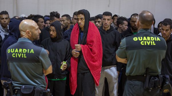 Guardia Civil officers stand guard in June 2018 as migrants stay at a makeshift emergency center in the south of Spain, after being rescued by Spain's Maritime Rescue Service.