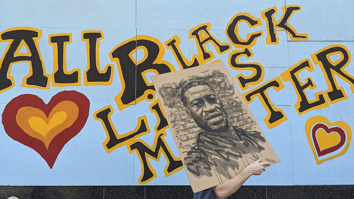 متظاهر يحمل صورة لجورج فلويد في ولاية كاليفورنيا 