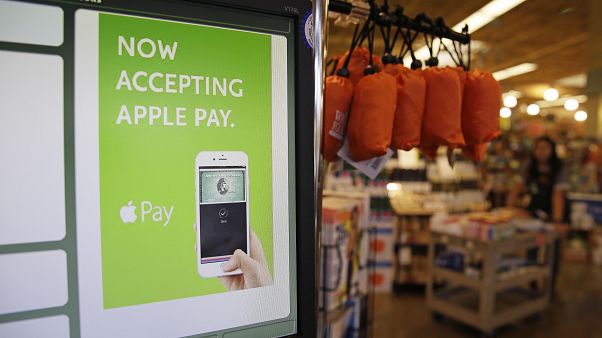 In this photo taken Friday, Oct. 17, 2014, a cash register terminal promotes usage of the new Apple Pay mobile payment system at a Whole Foods store in Cupertino, Calif. In this photo taken Friday, Oct. 17, 2014, a cash register terminal promotes usage of the new Apple Pay mobile payment system at a Whole Foods store in Cupertino, Calif.