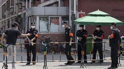 Des gardes de la sécurité à l'entrée d'un quartier bouclé de Pékin, le 16 juin 2020