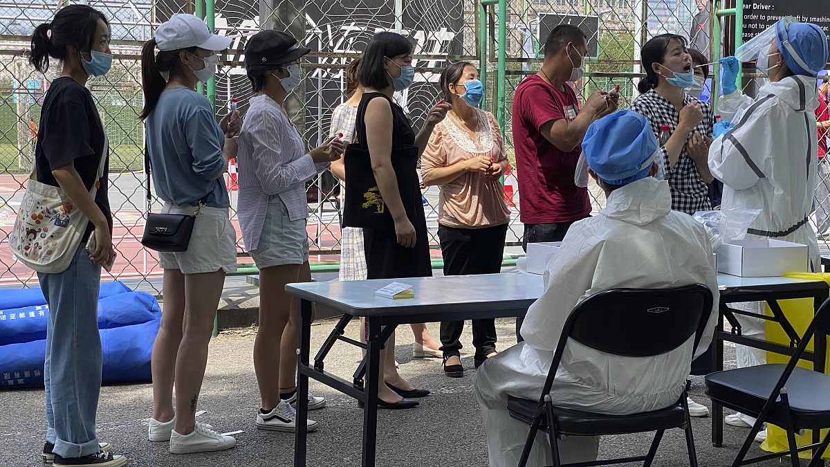 Koronavírus-tesztelésre várakoznak egy karantén alá vont negyed lakosai egy pekingi sportközpontban