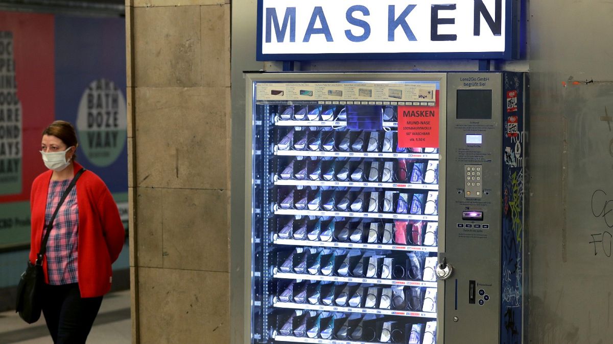 A woman walks past a vending machine that offers washable face masks in a station of the subway in Berlin, Germany, Monday, April 27, 2020