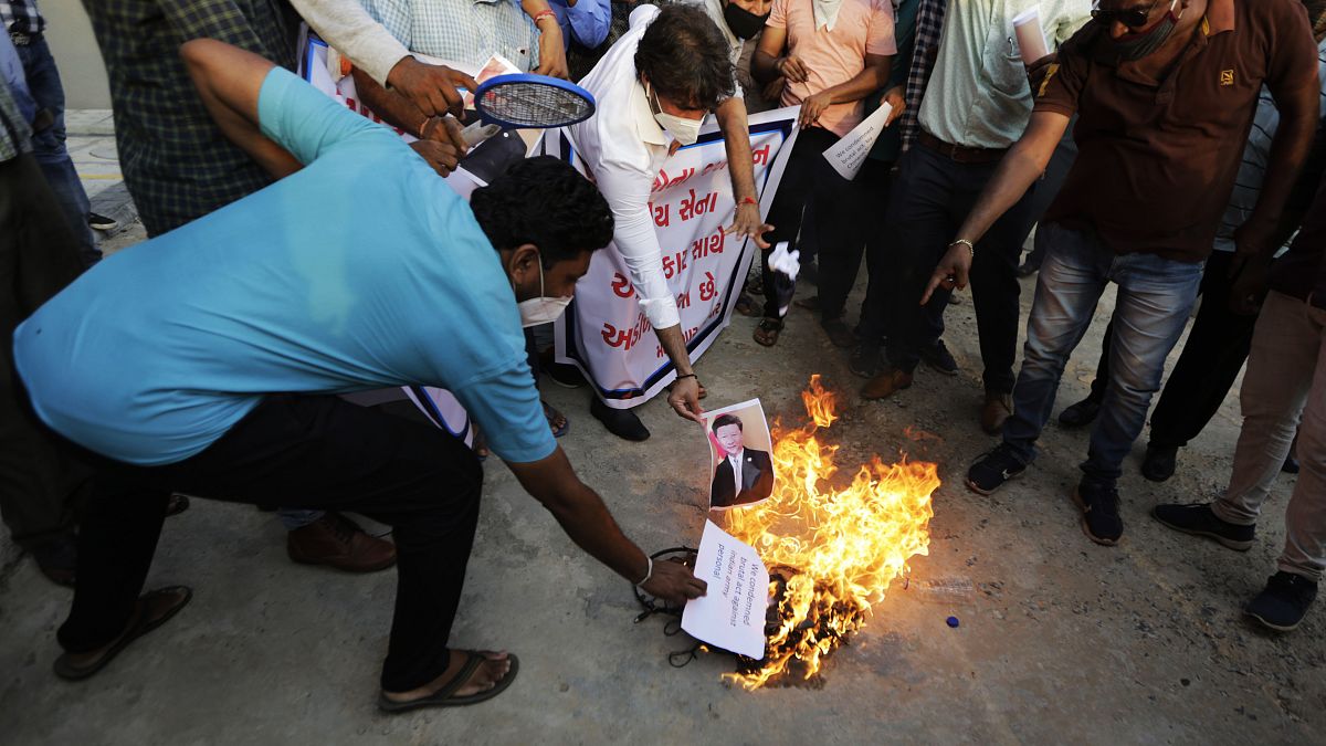 An Indian man burns a photograph of Chinese president Xi Jinping during a protest against China in Ahmedabad, India, Tuesday, June 16, 2020. 