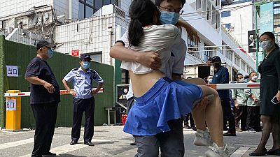 Una mujer es sacada en brazos de un centro de tests en Pekín