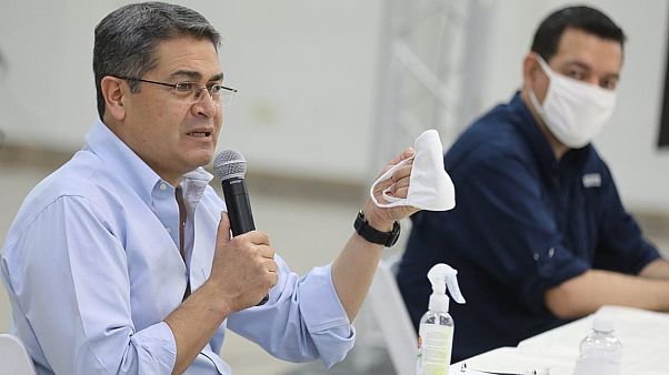 Honduras President Juan Orlando Hernandez holds a face mask during a press conference Honduras President Juan Orlando Hernandez holds a face mask during a press conference