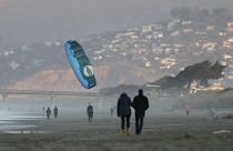 A windsurfer reels in his kite at New Brighton Beach in Christchurch, New Zealand, Tuesday, June 9, 2020.