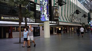 People in masks walk by Binion's casino Monday, June 15, 2020, in Las Vegas