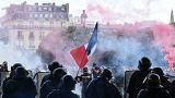 Protesters with a French flag face police during clashes on the Invalides esplanade at a demonstration in Paris. 16 June 2020