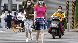 Residents wearing masks to curb the spread of the coronavirus cross the street in Beijing on Wednesday, June 17, 2020.