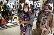 Women wearing protective face masks and gloves to help prevent the spread of the coronavirus shop at the Kourosh Shopping Center in Tehran, Iran