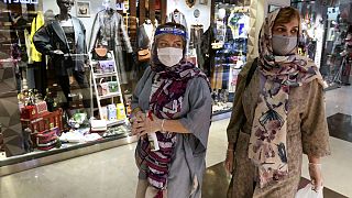 Women wearing protective face masks and gloves to help prevent the spread of the coronavirus shop at the Kourosh Shopping Center in Tehran, Iran