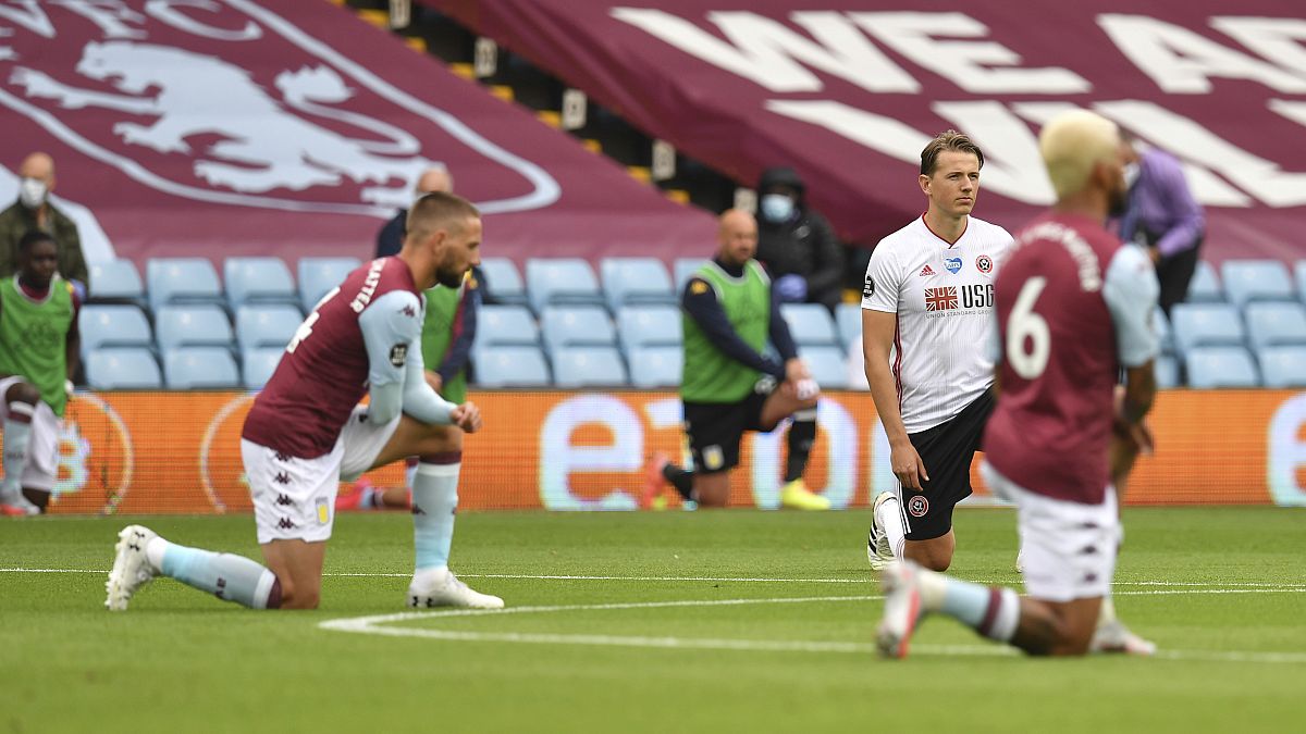 Players kneel prior to the start of the English Premier League soccer match between Aston Villa and Sheffield United at Villa Park in Birmingham, England, Wednesday, June 17, 