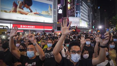 Protesters singing and gesture with five fingers, signifying the "Five demands - not one less" during a protest in Causeway Bay, Hong Kong, Friday, June 12, 2020. 