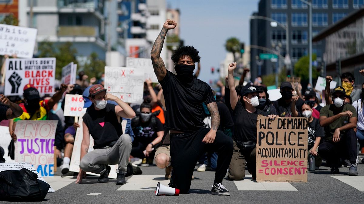 Des manifestants s'agenouillent dans un moment de silence devant le commissariat de Long Beach, le 31 mai 2020, lors d'une manifestation en mémoire à George Floyd.