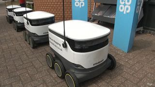 delivery robots lined up outside of grocery store