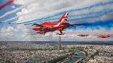 The Royal Air Force Aerobatic Team, the Red Arrows, and the French Air Force Aerobatic Team, La Patrouille de France, perform a fly-past over Paris, France