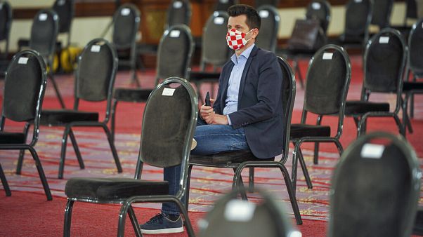 Egy horvát parlamenti képviselő várja az ülés kezdetét 2020 áprilisában. Egy horvát parlamenti képviselő várja az ülés kezdetét 2020 áprilisában.