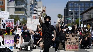  manifestantes se arrodillan en silencio frente a la comisaría de Long Beach el 31 de mayo de 2020, durante una manifestación en memoria de George Floyd.