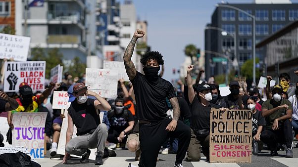 Manifestanti si inginocchiano per un momento di silenzio davanti al commissariato di Long Beach il 31 maggio scorso Manifestanti si inginocchiano per un momento di silenzio davanti al commissariato di Long Beach il 31 maggio scorso