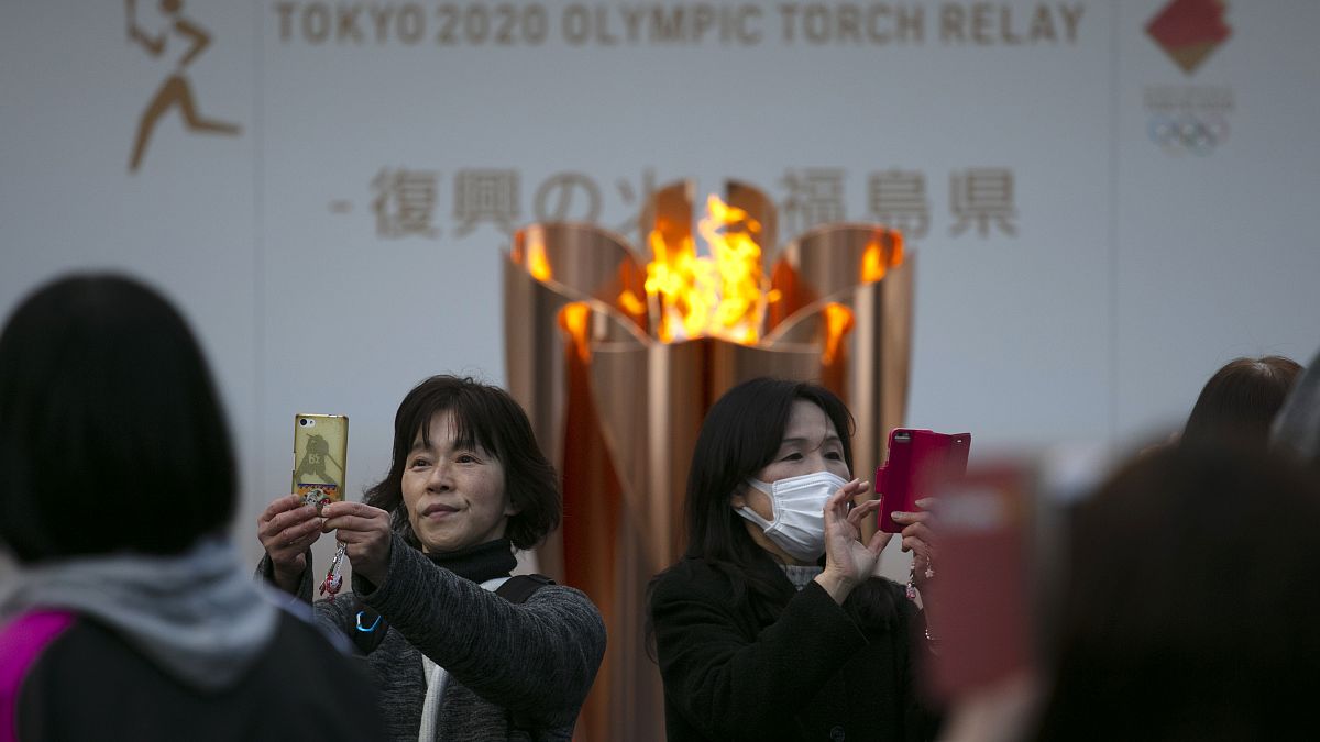 En esta foto de archivo del 24 de marzo de 2020, la gente se toma fotos con la Llama Olímpica durante una ceremonia en la ciudad de Fukushima, Japón.