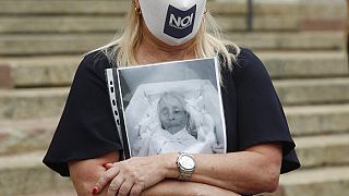 Μια γυναίκα, κρατά μια φωτογραφία της νεκρής μητέρας της