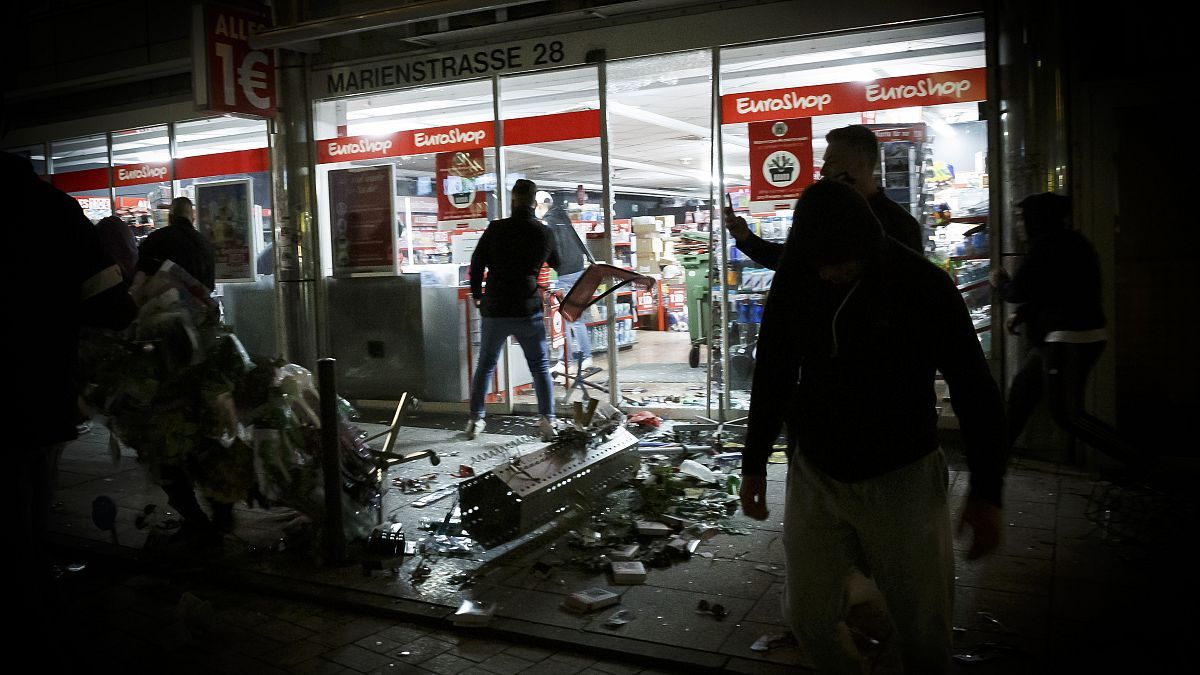 Goods lie on the floor after people broke into a shop on Marienstrasse in Stuttgart, Germany, Sunday, June 21, 2020.