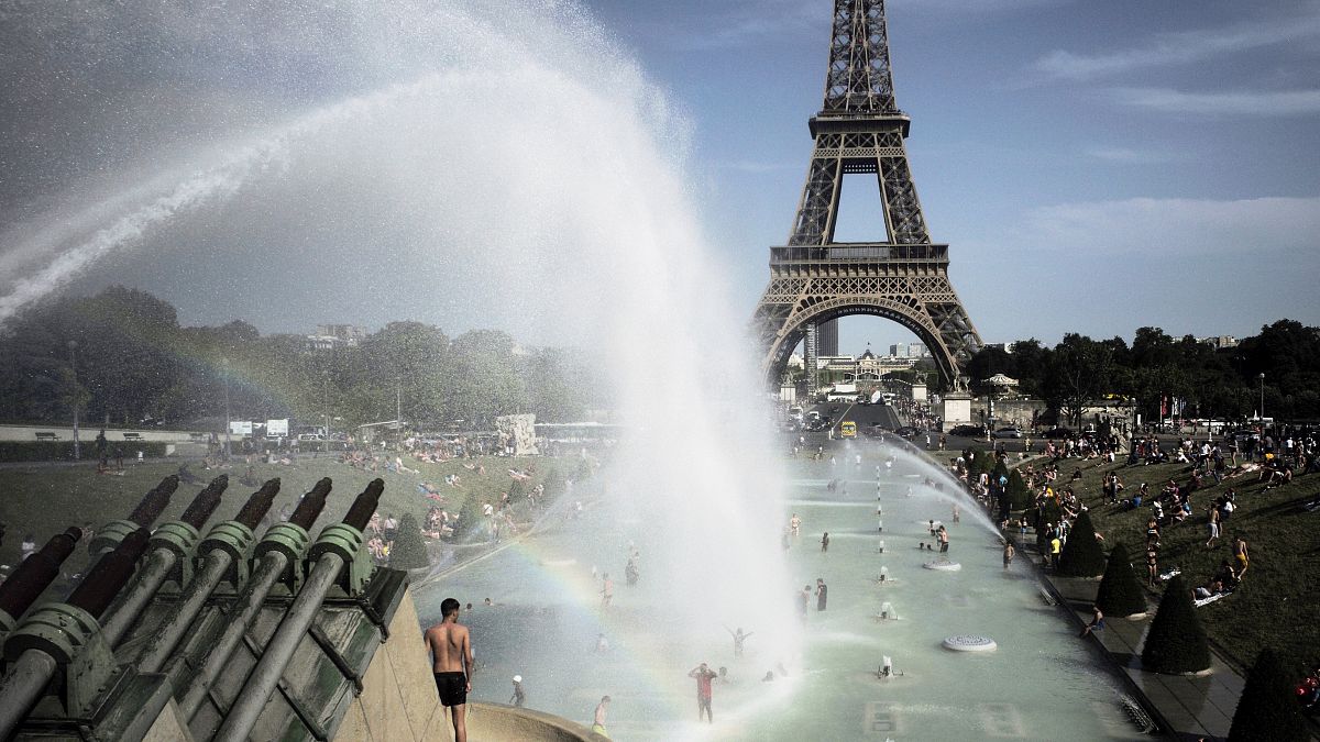 People cool off in the fountains of the Trocadero gardens, in front of the Eiffel Tower, in Paris, Friday, June 28, 2019.