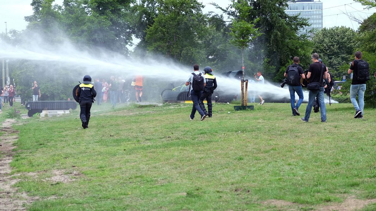 Police use a water cannon during a demonstration targeting the government’s handling of the coronavirus crisis, in Malieveld, the Hague, Netherlands, Sunday, June 21, 2020.