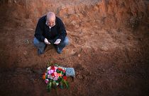 A Libyan man prays for a relative, one of many discovered in a mass grave,
