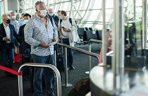 Passengers, wearing face masks to protect against the spread of coronavirus, queue up to board their plane at the Zaventem international airport. Brussels, Belgium