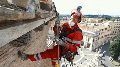 Rope-climbing workers help restore Rome landmark