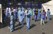 Juarez public hospital health workers wait on a street after a 7.5 earthquake sent them out from their work areas, in Mexico City, Tuesday, June 23, 2020. 