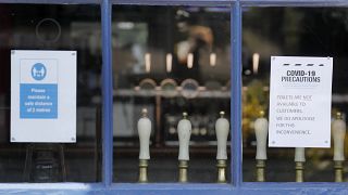 Draft tabs are seen through a window of a closed pub in London, Tuesday, June 23, 2020. Pubs are to reopen in a major easing of lockdown restrictions in England from July 4.