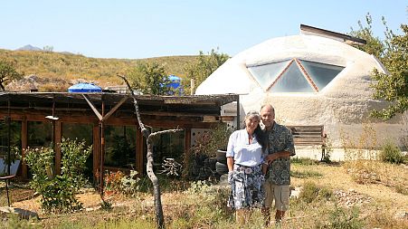 Laura Davies and Dave Buchanan standing outside their eco home.