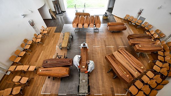 Des employés déchargent d'un camion militaire des cercueils arrivés de Bergame près de Milan pour être inhumés au cimetière Cinisello Balsamo le 27 mars Des employés déchargent d'un camion militaire des cercueils arrivés de Bergame près de Milan pour être inhumés au cimetière Cinisello Balsamo le 27 mars