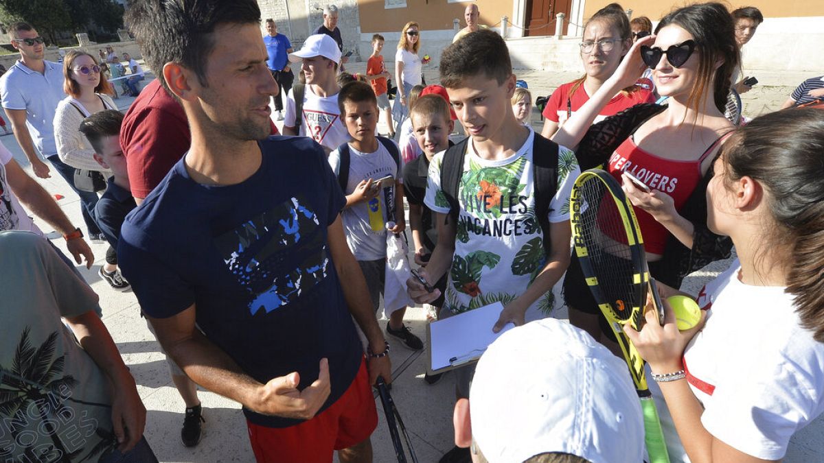 Novak Djokovic, left, talks to children in Zadar, Croatia. Djokovic has tested positive for the coronavirus after organising a tennis tournament in Serbia and Croatia.