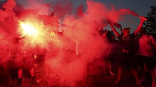 Un gruppo di tifosi del Liverpool festeggia la vittoria della Premier League davanti ad Anfield Road