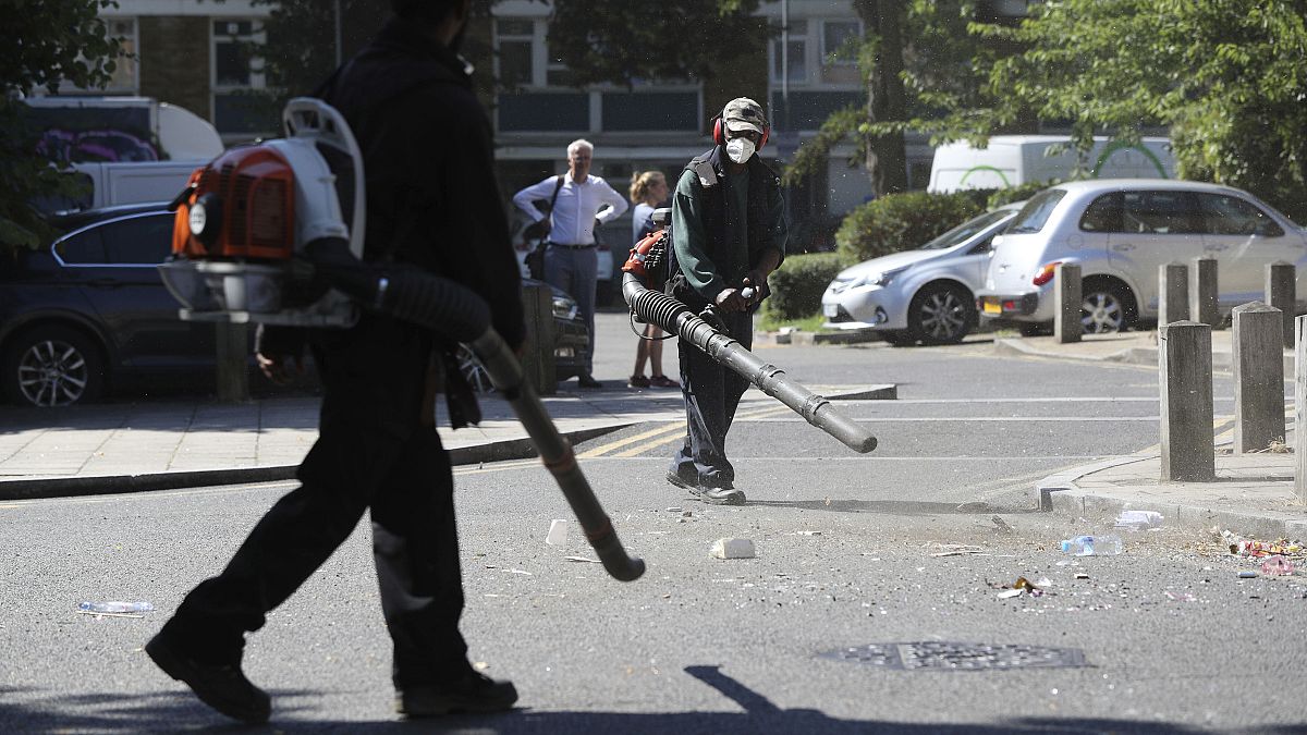 Volunteers clean up the streets following overnight violent confrontations in Brixton, London.