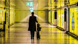 A woman walks with her suitcase down an empty corridor in the Rhine-Main Airport. 12 March 2020 