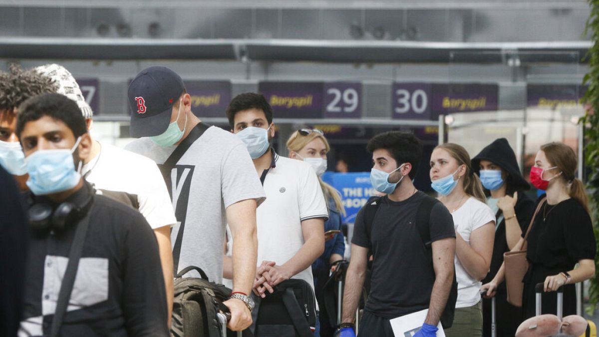 Passengers wearing face masks to protect against coronavirus pass check-in procedure at Boryspil International Airport outside Ukraine's capital Kyiv