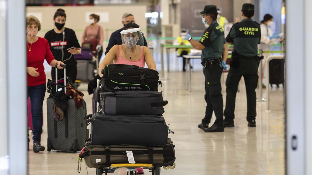 Pasajeros con mascarillas llegan al aeropuerto internacional Adolfo Suárez-Barajas, en las afueras de Madrid, España, el domingo 21 de junio de 2020. 