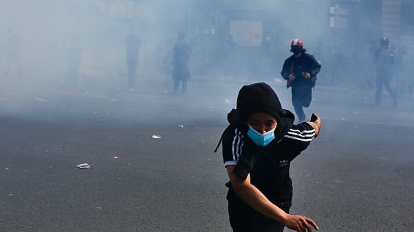 A protestor flees tear gas A protestor flees tear gas