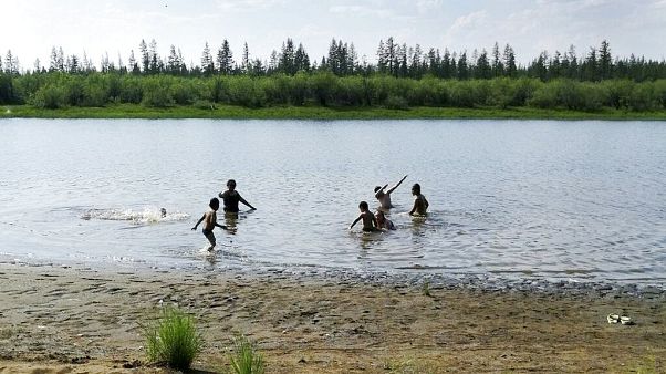 children play in the Krugloe lake outside Verkhoyansk, the Sakha Republic, about 4660 kilometers (2900 miles) northeast of Moscow, Russia. children play in the Krugloe lake outside Verkhoyansk, the Sakha Republic, about 4660 kilometers (2900 miles) northeast of Moscow, Russia.