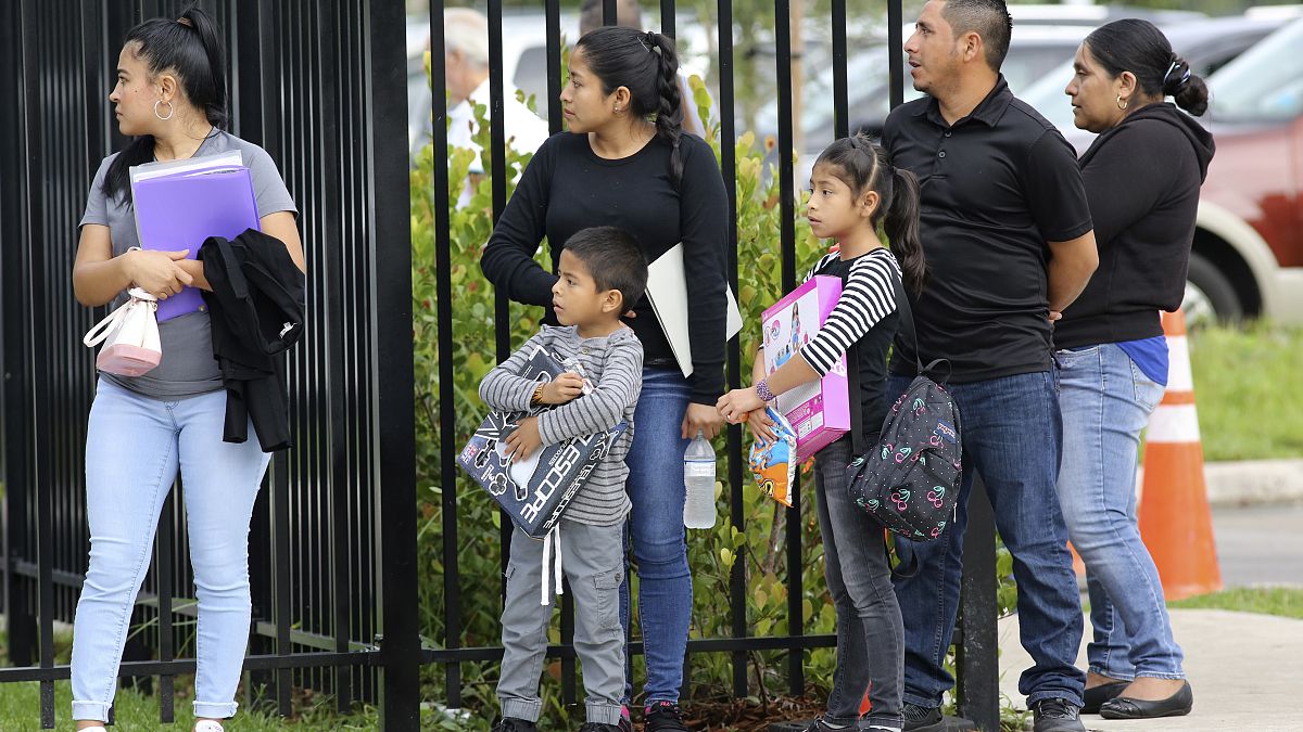 مهاجرون مع أطفالهم أمام مركز ميرامار للهجرة والجمارك في فلوريدا بالولايات المتحدة 