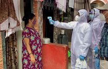 health workers going door-to-door and conducting temperature screening of residents