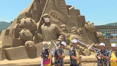 Government ministers getting ready to take down face mask on sand sculpture of health minister