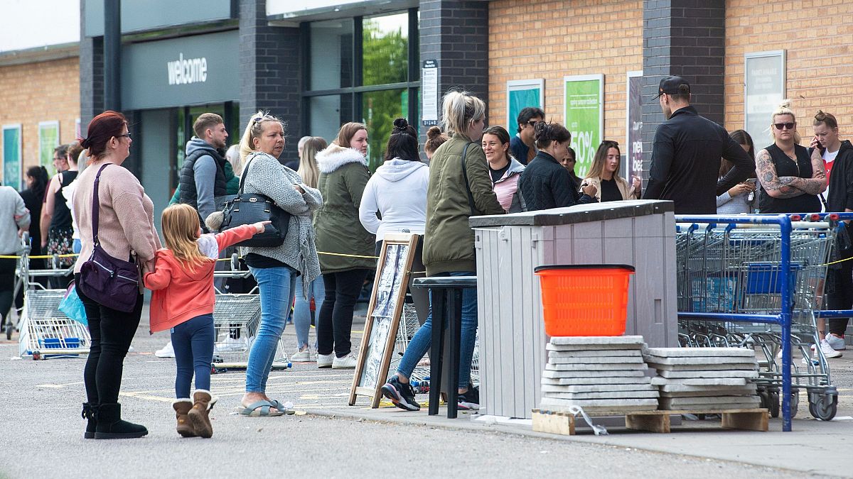 People queue outside a shop in Leicester amid coronavirus social-distancing measures