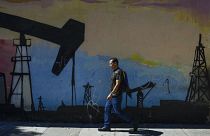 Un hombre pasa ante un mural en Caracas, Venezuela